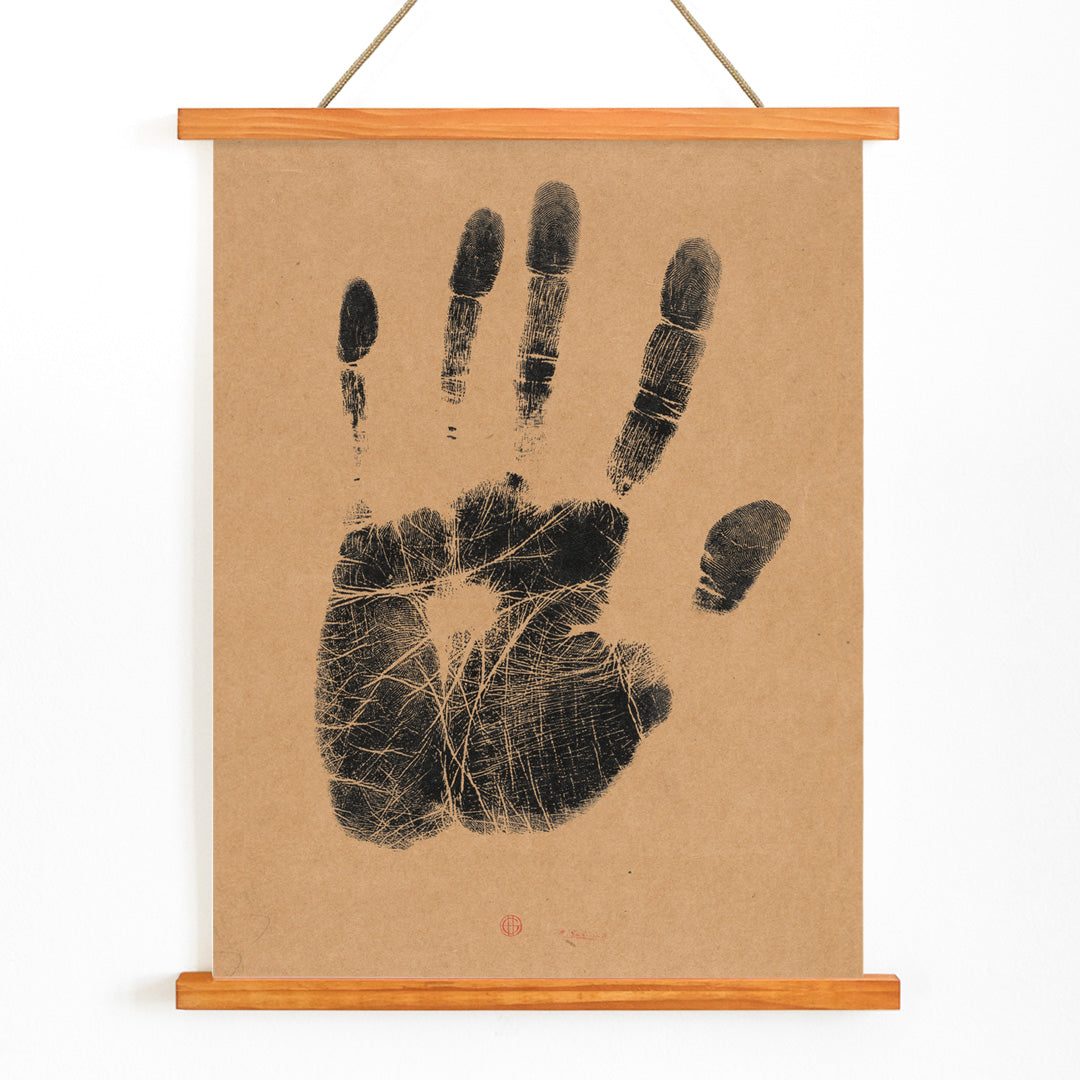 Black ink handprint artwork titled The Artists Left Hand by Henri Charles Guerard on beige background, with wooden magnetic frame on white background