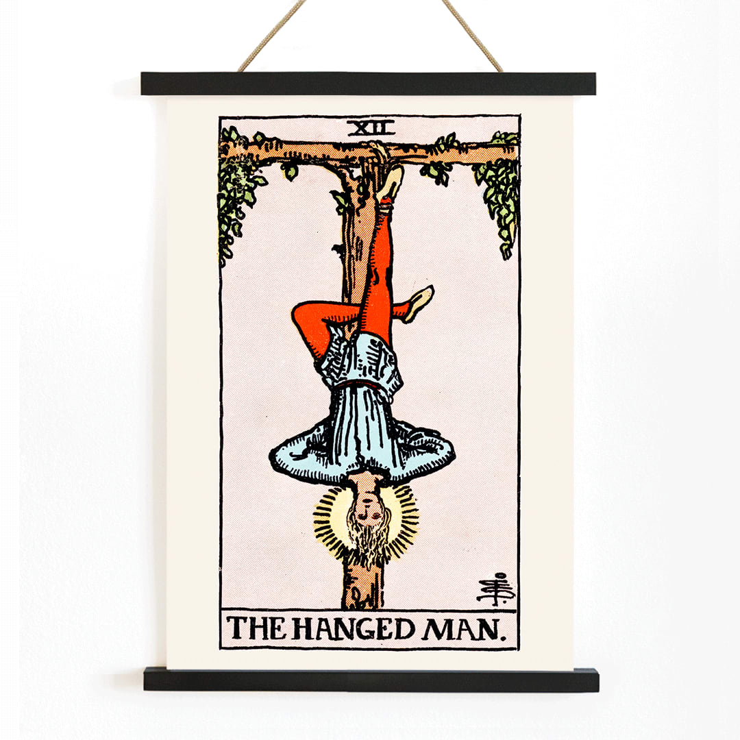 Hanged Man Tarot Card by Rider Waite, figure hanging upside down from wooden structure, mystical poster art, with wooden magnetic frame on white background