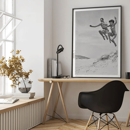 Two Tivoli Stars performing an acrobatic jump on a sandy beach in swimsuits Acrobatics at the Beach poster, framed and displayed in home decor