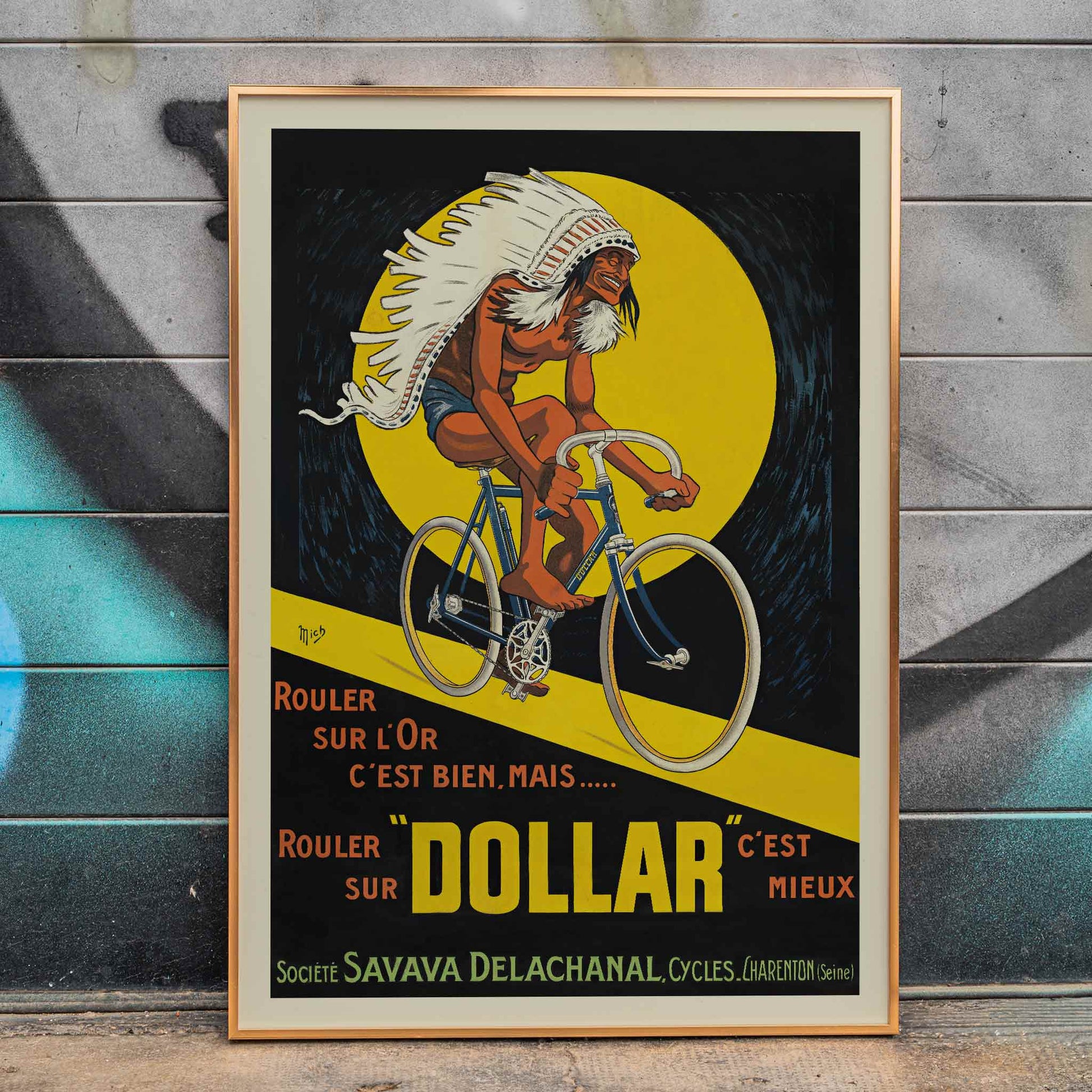 Michel Liebeaux Dollar Bicycles poster with advertising cyclist, white headdress, yellow circle, black background and bold orange lettering, framed and displayed in modern living room decor