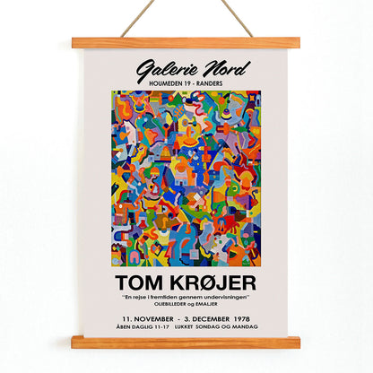 Colorful abstract artwork exhibition poster by Tom Krojer titled En rejse i fremtiden gennem undervisningen at Galerie Nord featuring bold geometric shapes, with wooden magnetic frame on white background