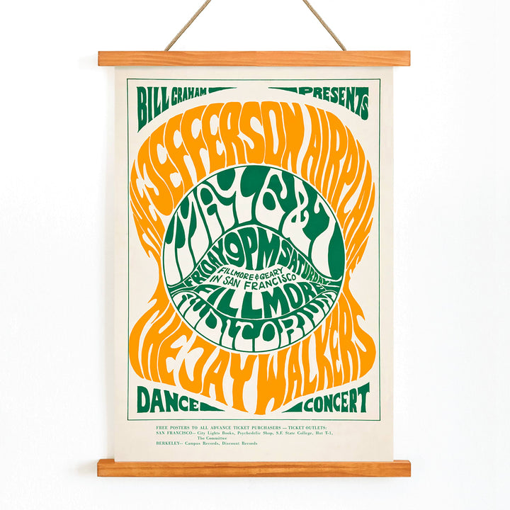 Psychedelic concert poster by Wes Wilson for The Jefferson Airplane and Jay Walkers at Fillmore Auditorium with vibrant orange and green text, with wooden magnetic frame on white background