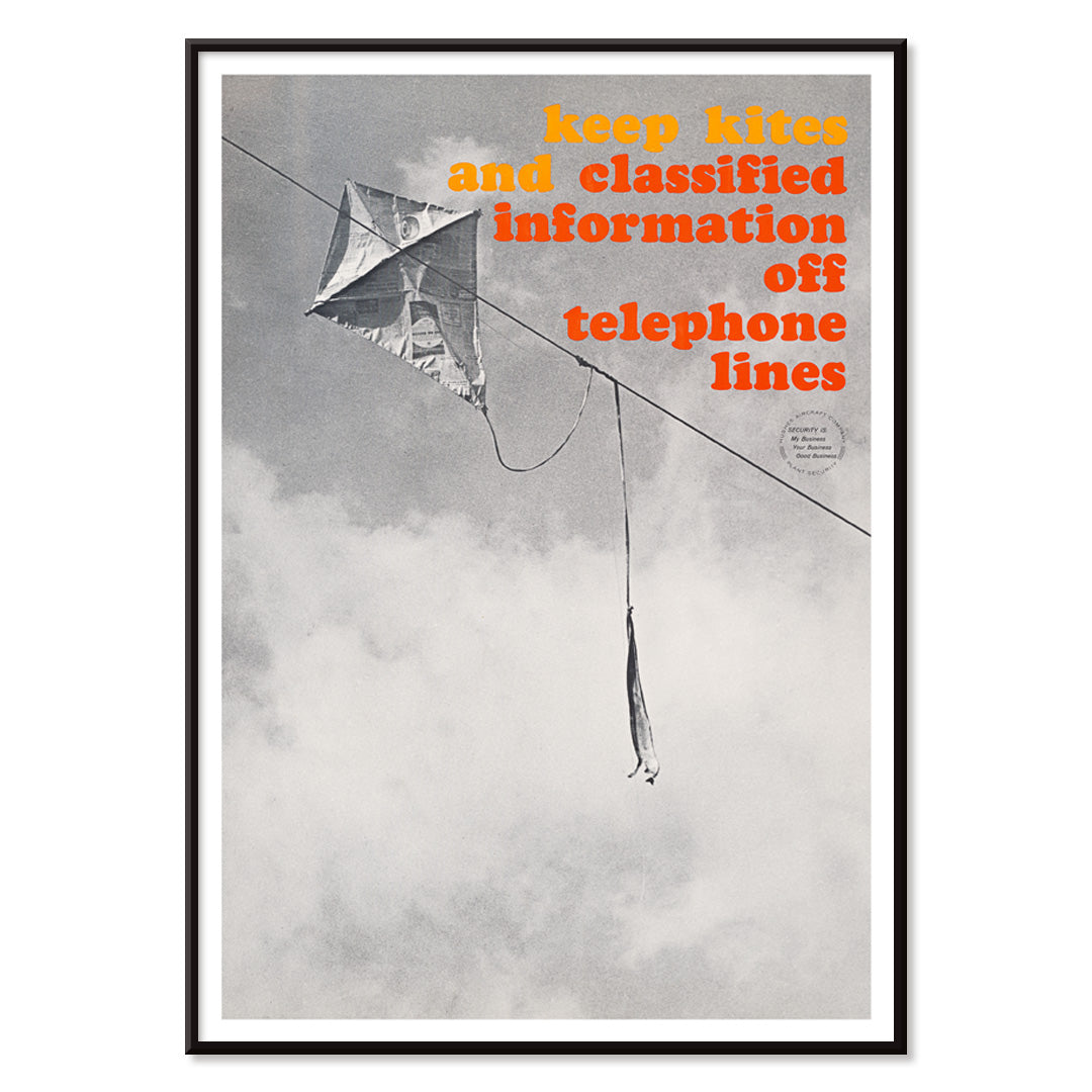 Black and white photo and poster of a kite tangled on a telephone line with bold warning text Keep kites and classified information off telephone lines, with black aluminium frame on white background