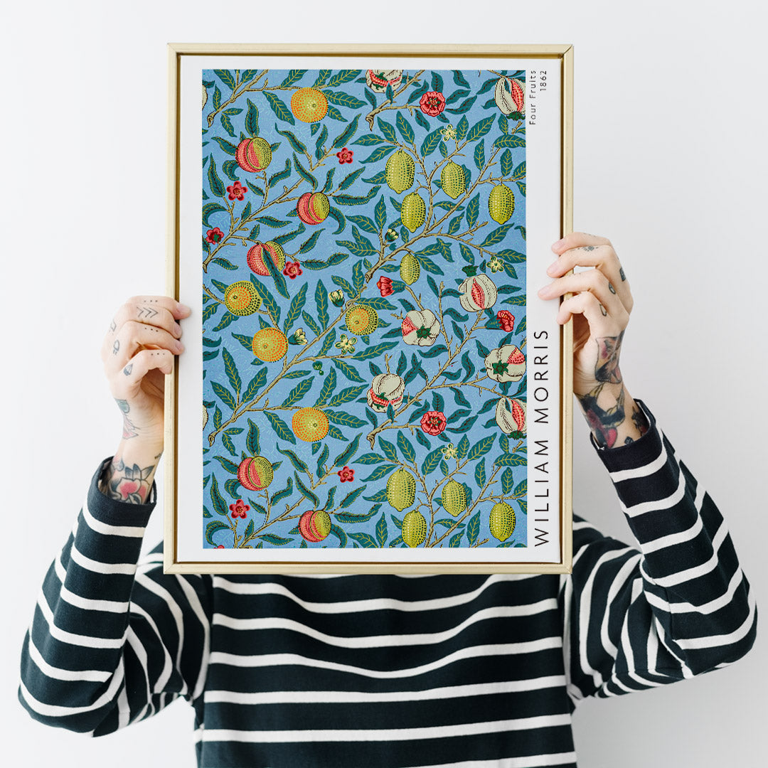Colorful botanical wallpaper and poster featuring fruits and leaves from Four Fruits pattern by William Morris on blue background for wall decor, framed and displayed in home decor