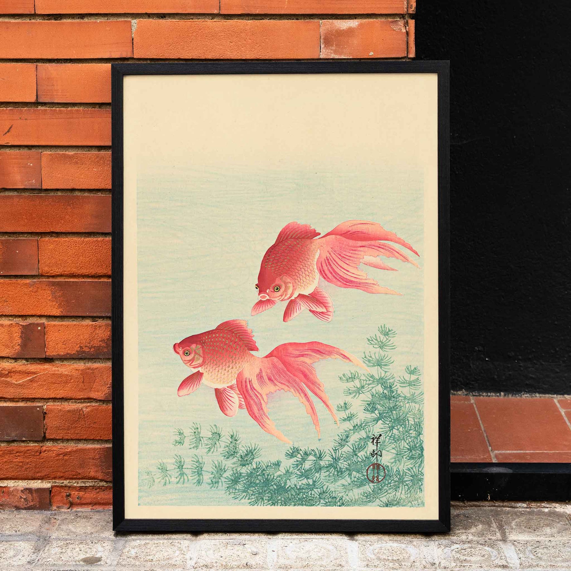 Two Goldfishes by Ohara Koson poster with two vibrant goldfish swimming among aquatic plants in blue water, framed and displayed in home decor