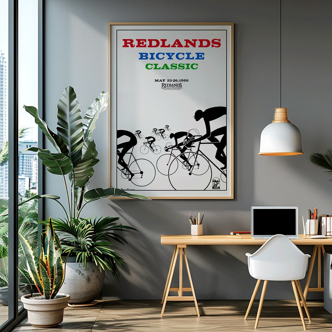 Cyclists racing illustration and poster by Karlis Smiltens titled Redlands Bicycle Classic featuring red blue and green text on white background, framed and displayed in home decor