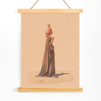 Water carrier by Emile Prisse dAvennes woman in traditional attire carrying water jug on head in desert scene artwork, with wooden magnetic frame on white background